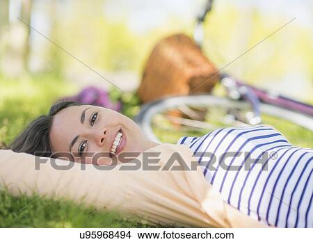 Picture - Portrait of mid adult woman relaxing in park. Fotosearch