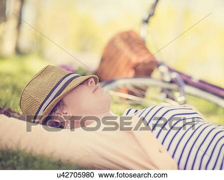 Portrait of mid adult woman relaxing in park View Large Photo Image Stock Image - Portrait of mid adult woman relaxing in park. Fotosearch