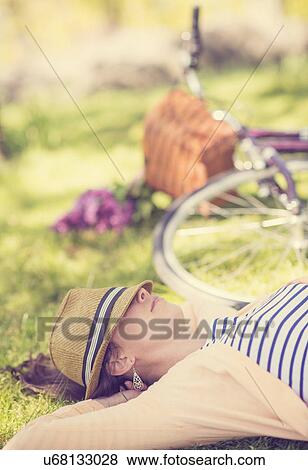 Portrait of mid adult woman relaxing in park View Large Photo Image Stock Photo - Portrait of mid adult woman relaxing in park. Fotosearch