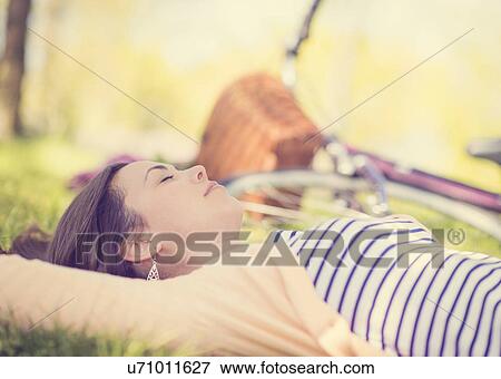 Portrait of mid adult woman relaxing in park View Large Photo Image Stock Photo - Portrait of mid adult woman relaxing in park. Fotosearch