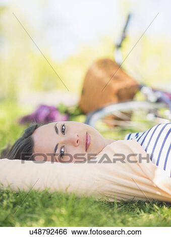 Portrait of mid adult woman relaxing in park View Large Photo Image Stock Photograph - Portrait of mid adult woman relaxing in park. Fotosearch