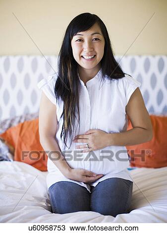 Portrait of pregnant woman sitting on bed View Large Photo Image Stock Image - Portrait of pregnant woman sitting on bed. Fotosearch