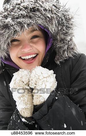 Stock Photograph - Portrait of smiling woman in warm clothing at winter. Fotosearch
