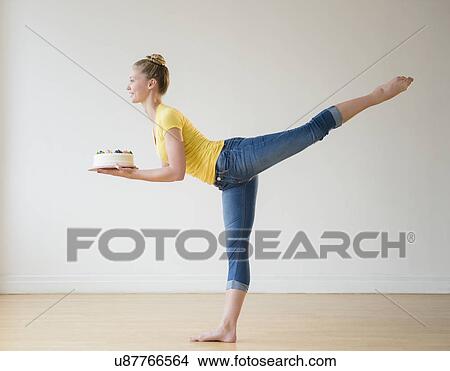Picture - Portrait of teenage (16-17) ballerina holding cake. Fotosearch