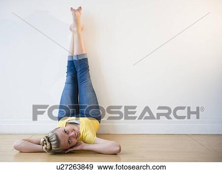 Stock Photo - Portrait of teenage (16-17) ballerina lying down with feet up against wall. Fotosearch