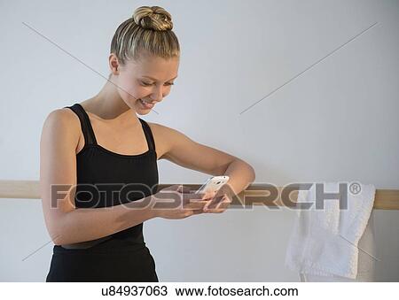 Portrait of teenage (16-17) ballet dancer standing at barre and using mobile phone View Large Photo Image Stock Image - Portrait of teenage (16-17) ballet dancer standing at barre and using mobile phone. Fotosearch