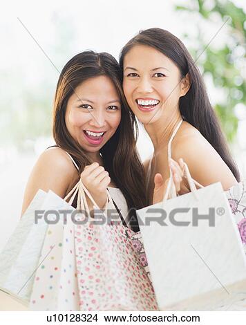 Picture - Portrait of two women with shopping bags. Fotosearch