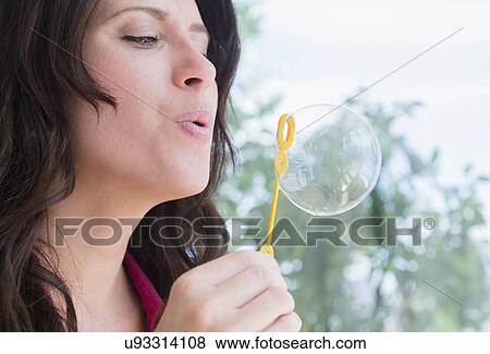 Portrait of woman blowing bubble View Large Photo Image Stock Photo - Portrait of woman blowing bubble. Fotosearch