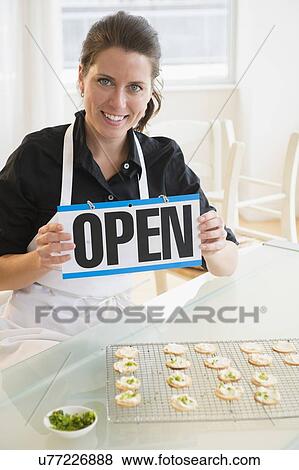 Portrait of woman holding open sign View Large Photo Image Stock Photo - Portrait of woman holding open sign. Fotosearch