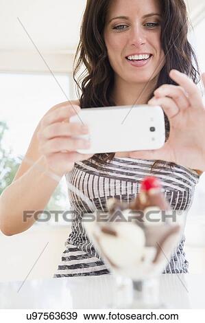 Portrait of woman photographing ice cream sundae View Large Photo Image Stock Photo - Portrait of woman photographing ice cream sundae. Fotosearch