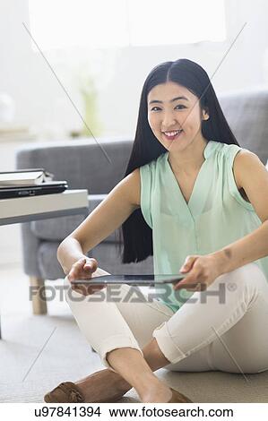Picture - Portrait of woman using tablet pc at home. Fotosearch