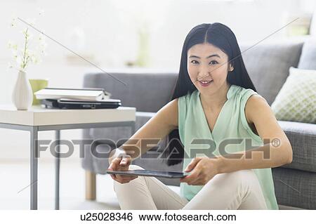 Stock Photograph - Portrait of woman using tablet pc at home. Fotosearch