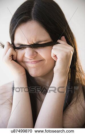 Stock Image - Portrait of young woman with angry face expression. Fotosearch