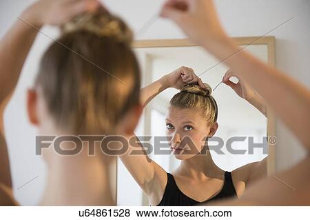 Rear view of teenage (16-17) ballerina looking into mirror and styling her hair View Large Photo Image Stock Photo - Rear view of teenage (16-17) ballerina looking into mirror and styling her hair. Fotosearch
