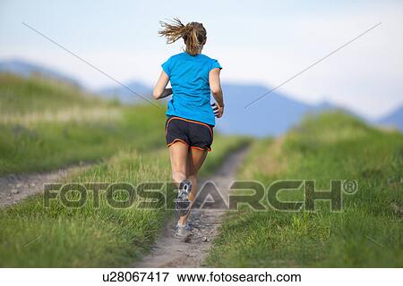 Rear view of young woman jogging View Large Photo Image Stock Photo - Rear view of young woman jogging. Fotosearch