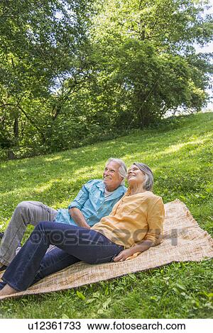 Senior couple relaxing in park View Large Photo Image Stock Image - Senior couple relaxing in park. Fotosearch