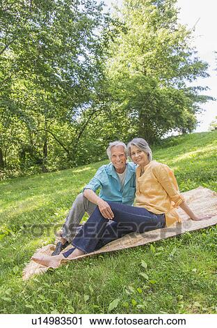 Stock Image - Senior couple relaxing in park. Fotosearch