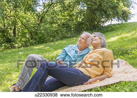 Stock Photo - Senior couple relaxing in park. Fotosearch