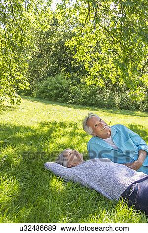 Stock Photo - Senior couple relaxing in park. Fotosearch