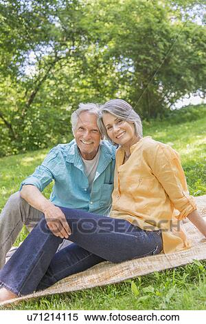 Stock Photography - Senior couple relaxing in park. Fotosearch