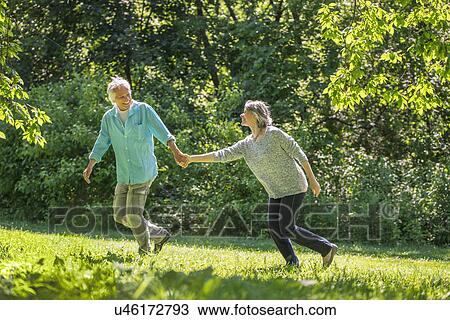 Senior couple running in park View Large Photo Image Stock Image - Senior couple running in park. Fotosearch