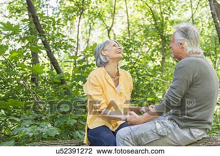 Senior couple sitting on log in forest View Large Photo Image Stock Image - Senior couple sitting on log in forest. Fotosearch