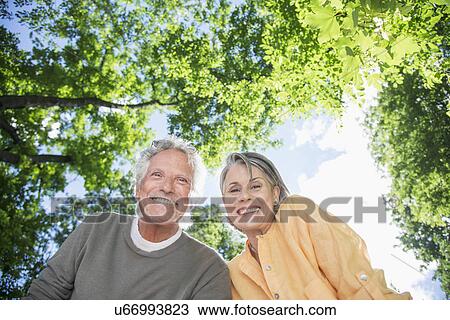 Stock Image - Senior couple under trees. Fotosearch