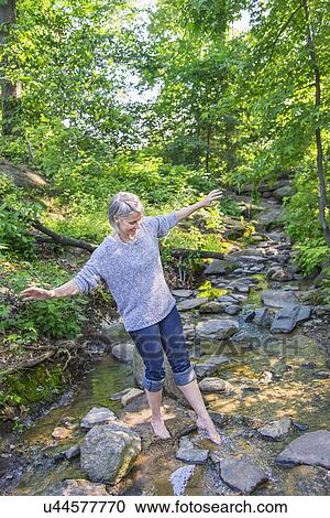 Senior woman crossing stream View Large Photo Image Stock Image - Senior woman crossing stream. Fotosearch