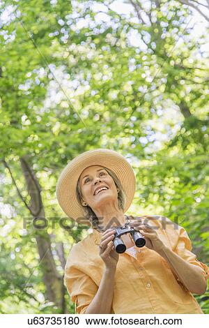 Senior woman with binoculars in park View Large Photo Image Stock Image - Senior woman with binoculars in park. Fotosearch