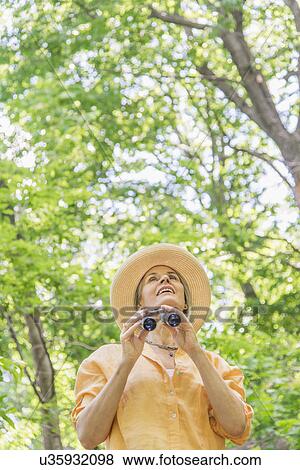 Senior woman with binoculars in park View Large Photo Image Stock Photo - Senior woman with binoculars in park. Fotosearch