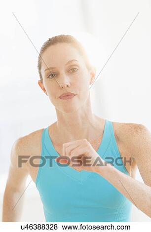Stock Photo - Studio portrait of woman exercising. Fotosearch