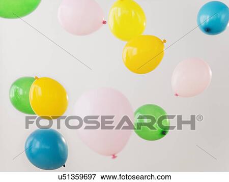 Studio Shot of colorful balloons falling down View Large Photo Image Stock Photo - Studio Shot of colorful balloons falling down. Fotosearch