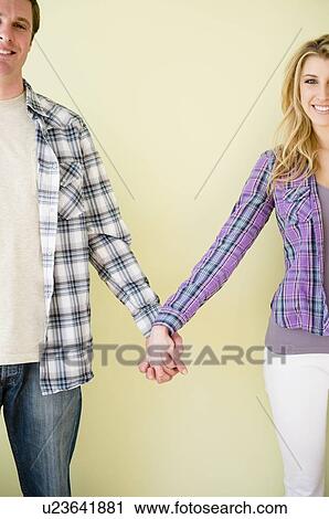 Studio shot of couple holding hands View Large Photo Image Stock Image - Studio shot of couple holding hands. Fotosearch