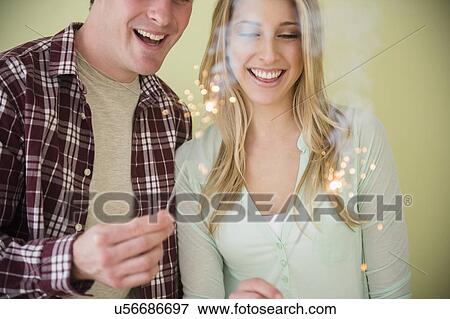 Studio shot of couple holding sparklers View Large Photo Image Stock Photo - Studio shot of couple holding sparklers. Fotosearch