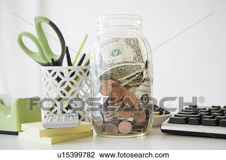 Studio Shot of jar full of money on desk View Large Photo Image Stock Image - Studio Shot of jar full of money on desk. Fotosearch
