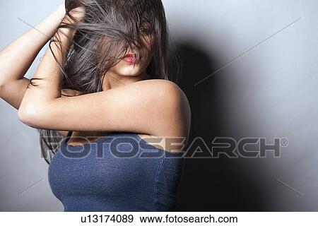 Studio shot of young woman covering her face View Large Photo Image Stock Photo - Studio shot of young woman covering her face. Fotosearch