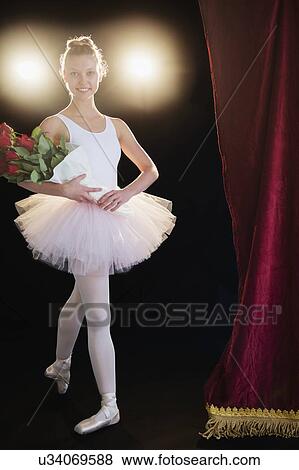 Teenage (16-17) ballerina on stage holding bunch of roses View Large Photo Image Stock Photo - Teenage (16-17) ballerina on stage holding bunch of roses. Fotosearch