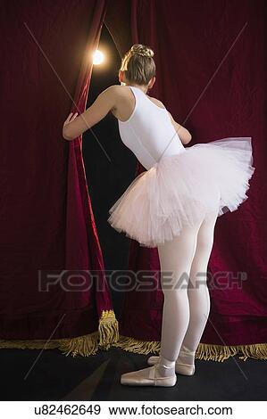 Teenage (16-17) ballerina on stage looking through curtain View Large Photo Image Stock Photo - Teenage (16-17) ballerina on stage looking through curtain. Fotosearch