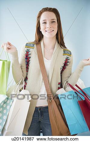 Teenage girl (14-15) carrying shopping bags, studio shot View Large Photo Image Stock Photo - Teenage girl (14-15) carrying shopping bags, studio shot. Fotosearch