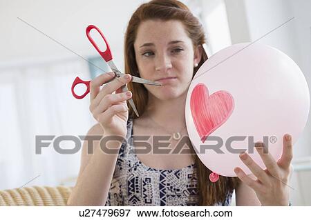 Teenage girl (14-15) holding balloon and scissors View Large Photo Image Stock Photo - Teenage girl (14-15) holding balloon and scissors. Fotosearch