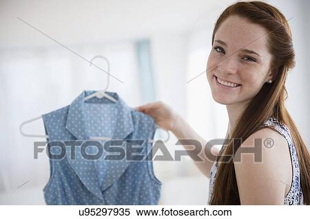 Teenage girl (14-15) holding dress View Large Photo Image Stock Photography - Teenage girl (14-15) holding dress. Fotosearch
