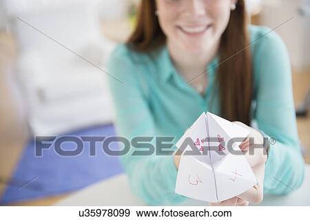 Stock Photo - Teenage girl (14-15) showing origami. Fotosearch