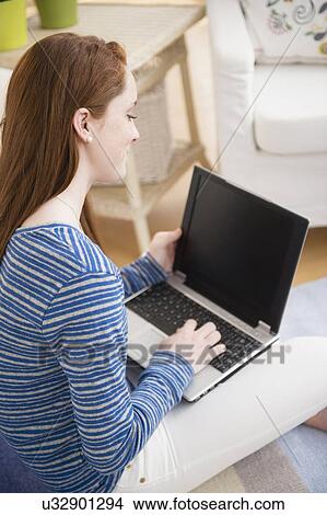 Picture - Teenage girl (14-15) studying with laptop. Fotosearch