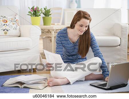 Picture - Teenage girl (14-15) studying with laptop. Fotosearch