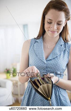 Stock Image - Teenage girl (14-15) with wallet. Fotosearch