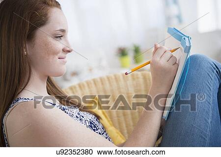 Teenage girl (14-15) writing in notebook View Large Photo Image Stock Image - Teenage girl (14-15) writing in notebook. Fotosearch