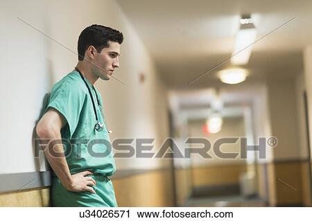 Tired doctor standing in hallway View Large Photo Image Stock Image - Tired doctor standing in hallway. Fotosearch