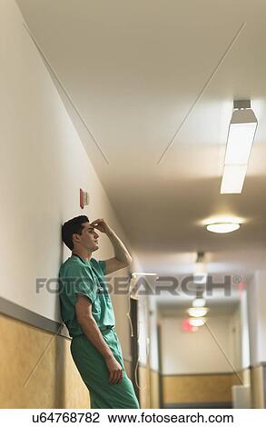 Tired doctor standing in hallway View Large Photo Image Stock Image - Tired doctor standing in hallway. Fotosearch