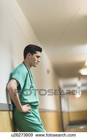 Stock Photo - Tired doctor standing in hallway. Fotosearch
