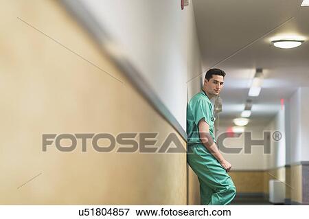 Tired doctor standing in hallway View Large Photo Image Stock Photo - Tired doctor standing in hallway. Fotosearch